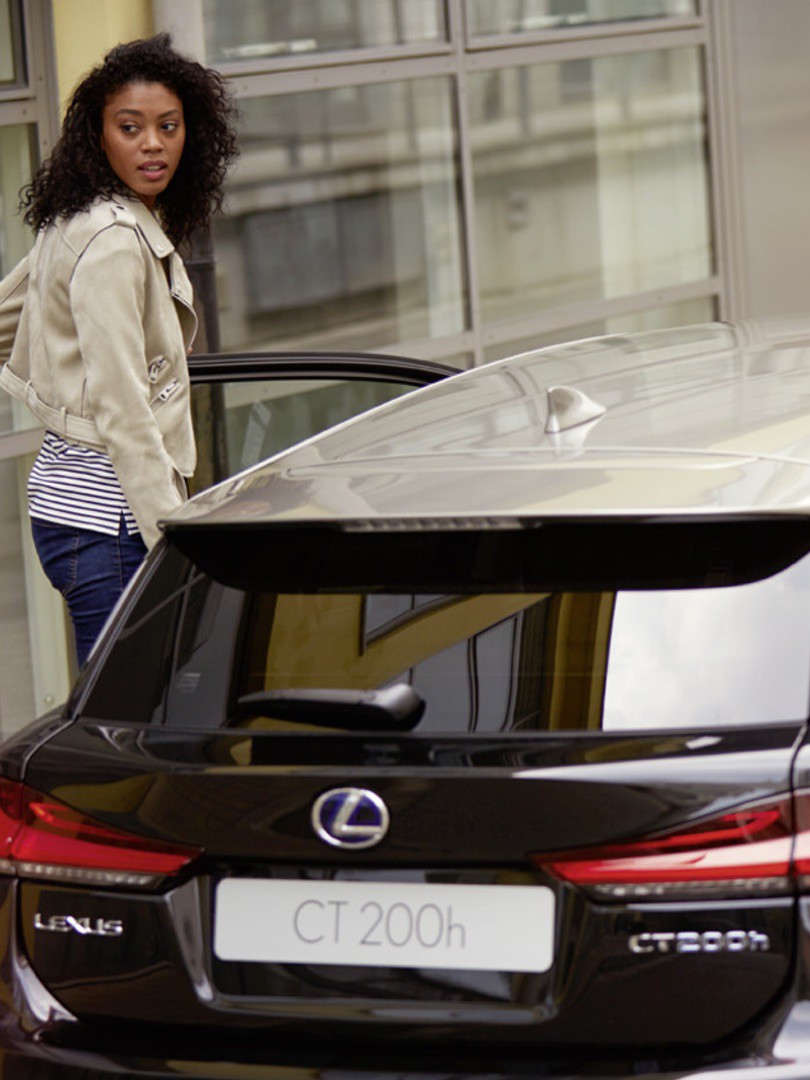 Frau neben einem Lexus CT200h