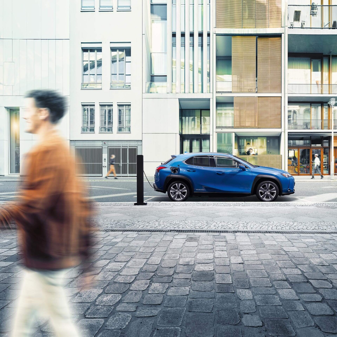 Ein Lexus UX300e lädt an einer Säule am Straßenrand