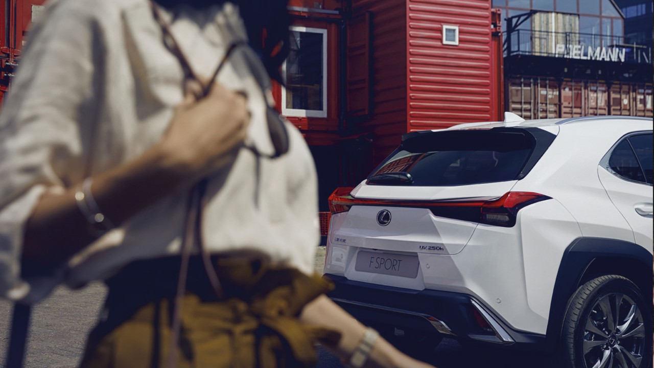 Frau hinter Lexus F SPORT mit Tasche