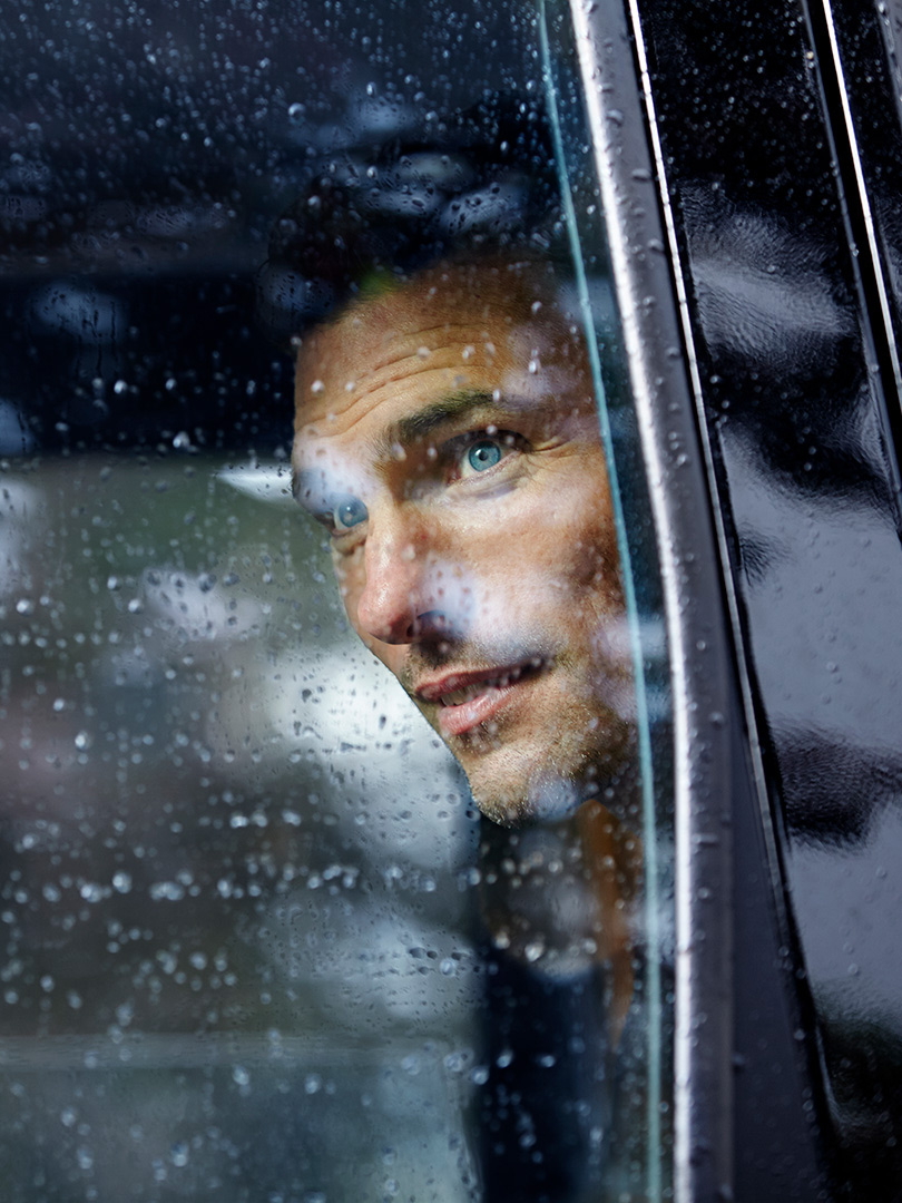 Mann schaut bei Regen aus dem Autofenster