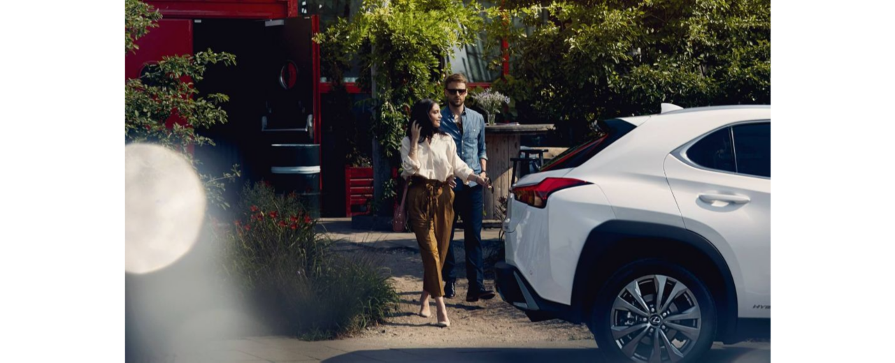 Paar auf der Straße hinter weißem Lexus