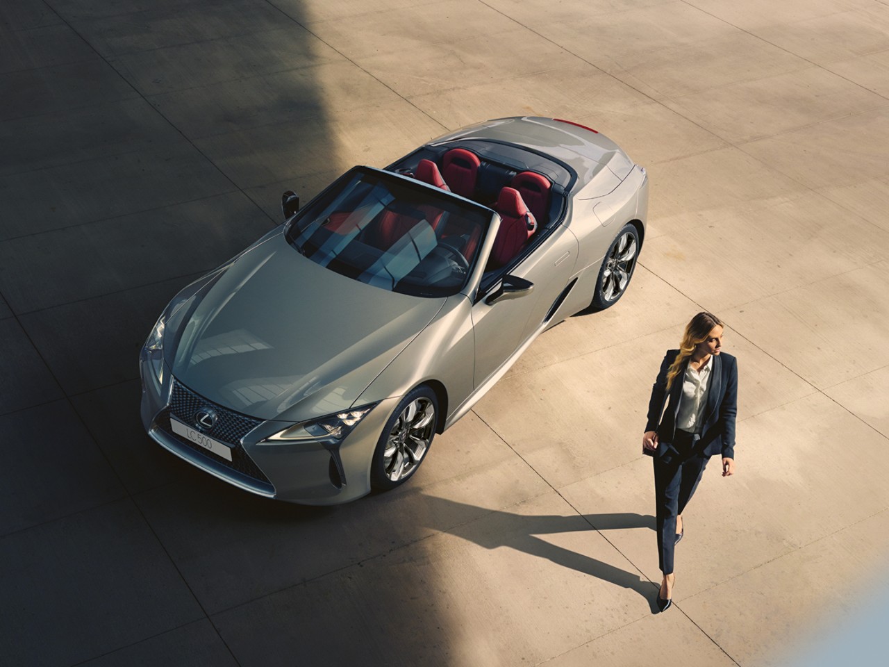 A person standing next to a Lexus LC Convertible