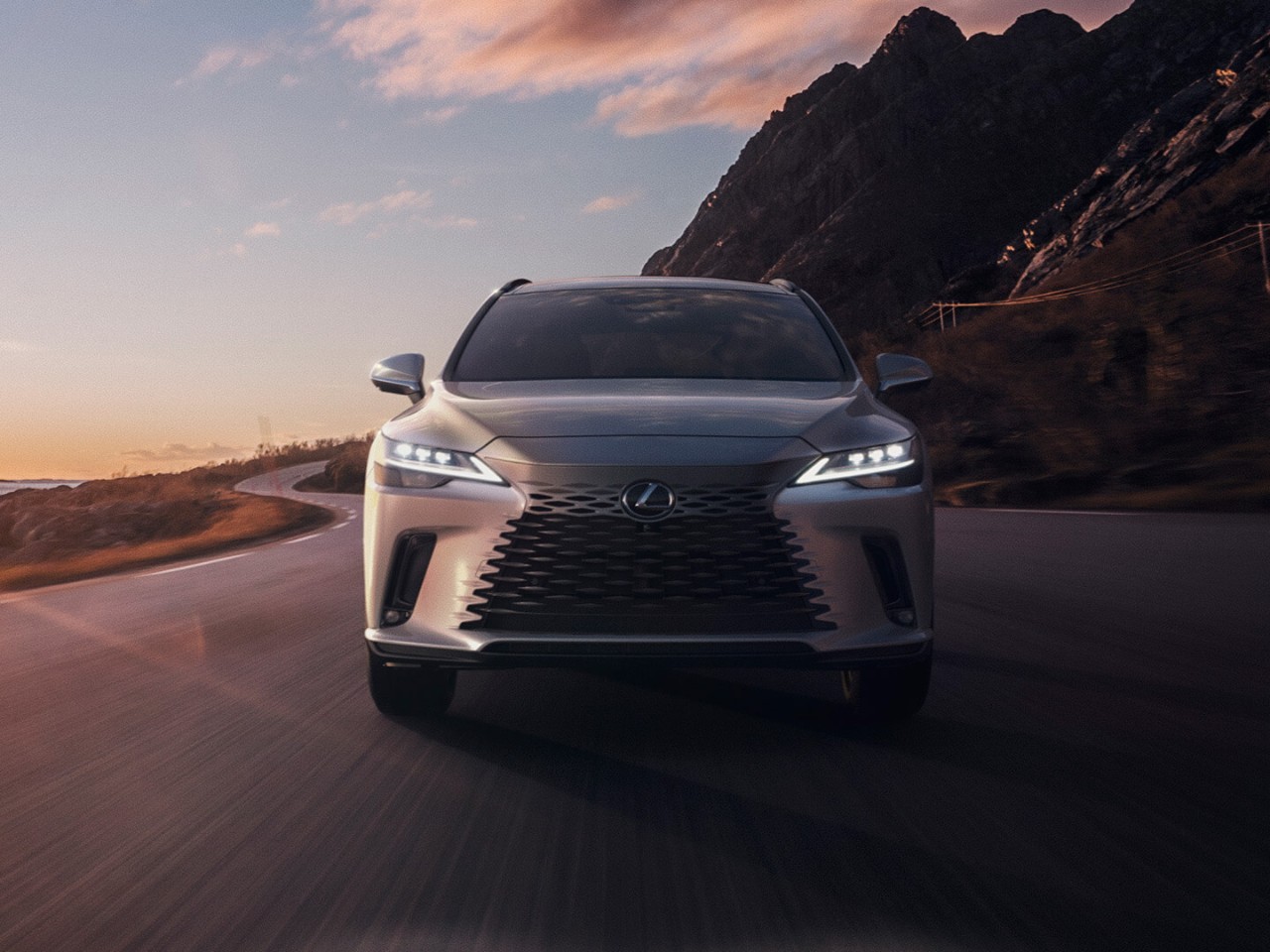 Front view of a Lexus RX driving on a coastal road