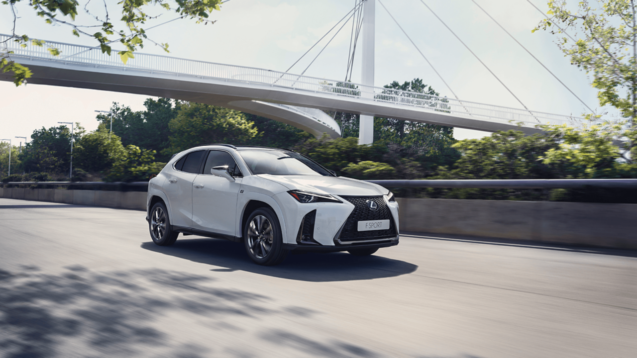 Weißer Lexus UX unter einer Brücke